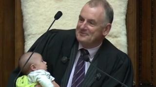 Le président du parlement néo-zélandais Trevor Mallard berce le bébé d'un député pendant un débat.