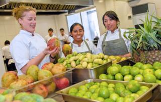 Mujer sostiene un mango.