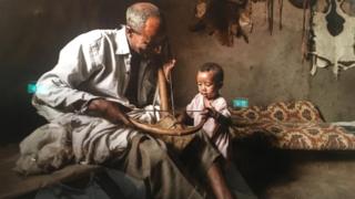 አንድ አዝማሪ ህፃን ልጅ በማጫወት ላይ