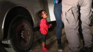 Una niña mira al agente de la Patrulla Fronteriza.