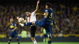 Players challenge a ball at a Boca v River match
