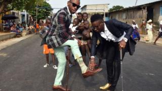 Les "sapeurs" à Abidjan au Femua, rendent hommage à Papa Wemba, musicien qui était connu pour son élégance.