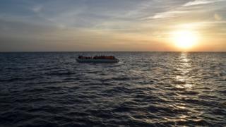 Migrants and refugees sit on a rubber boat before being rescued by the ship Topaz Responder run by Maltese NGO Moas and Italian Red Cross off the Libyan coast in the Mediterranean Sea, on November 5, 2016.