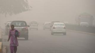 An Indian woman walks on a road during heavy smog conditions in New Delhi on November 7, 2017.