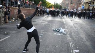 Una mujer arroja una botella.