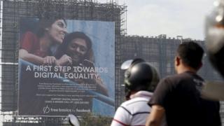 Motorists ride past a billboard displaying Facebook"s Free Basics initiative in Mumbai, India, December 30, 2015