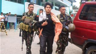 На этом снимке, сделанном 23 августа 2016 года, показаны филиппинские солдаты, сопровождающие члена экстремистской группы Maute Хасима Балавага Maute под псевдонимом Apple Jehad в военный автомобиль в городе Марави на южном острове Минданао