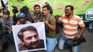Пакистанские журналисты в Карачи держат фотографию Ахмеда Нурани, старшего журналиста местной газеты, который был избит неизвестными нападавшими (30 октября 2017 г.)