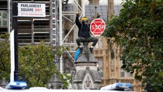 Protester on wall around Houses of Parliament