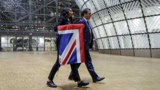 EU Council staff members remove the United Kingdom's flag from the European Council building in Brussels on Brexit Day, January 31, 2020