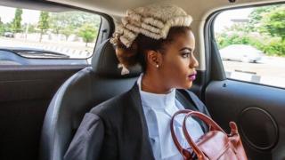 A Nigerian law graduate looks out of a car window