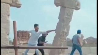 హంపిలో స్తంభాన్ని పడదోస్తున్న ముగ్గరు యువకులు