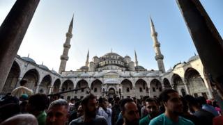 Muslim worshippers leave the Blue Mosque after the Eid al-Fitr prayers in Istanbul, 25 June