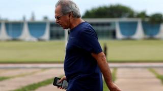 Paulo Guedes com roupa esportiva caminhando em frente ao Palácio da Alvorada