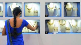 An employee of an Indian jewellery store arranges gold jewellery in Bangalore on 11 August 2017.