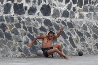 A man plays a pre-Columbian ballgame called "Ulama" -in Nahuatl indigenous language- which rule is to hit a "Ulamaloni" (solid rubber ball) with the hip or shoulder, during a match at the FARO Poniente cultural centre in Mexico City on August 21, 2019