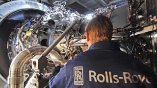 A Rolls-Royce employee working on an engine