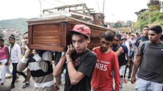 Pessoas carregam caixão em funeral na Venezuela