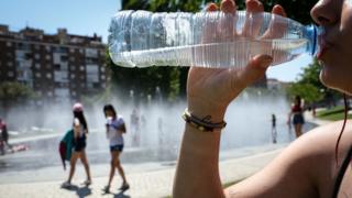 Mujer bebiendo agua durante una ola de calor