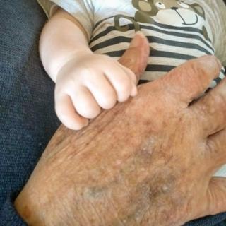 A 94-year-old hand and a newborn baby hand
