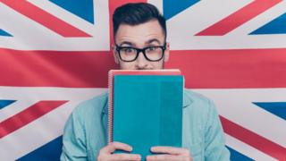Un hombre con una bandera británica detrás