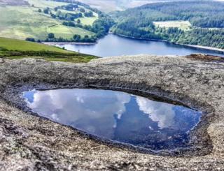 Clouds reflected in a puddle