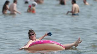 Die Menschen genießen das heiße Wetter am Southend Beach in Essex. 8. August 2020