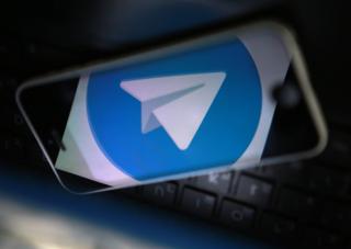 Смартфон и логотип мессенджера Telegram