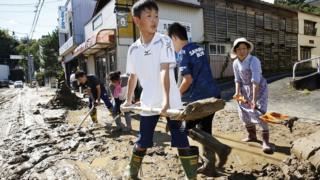 Schoolchildren and residents remove mud after flooding caused by Typhoon Hagibis in Marumori, Miyagi prefecture, Japan, October 13, 2019