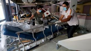 Staff move a gurney in a damaged hospital