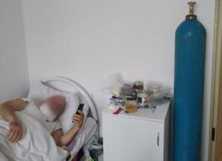 Man in hospital with oxygen canister