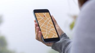 Young woman using GPS map direction on smartphone app.