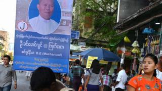 စည်ပင် ရွေးကောက်ပွဲ မဲဆွယ် ဆိုင်းဘုတ် တစ်ခု ရှေ့က ရန်ကုန် မြင်ကွင်းကို မတ်လ ၈ ရက်နေ့က မြင်တွေ့ရပုံ