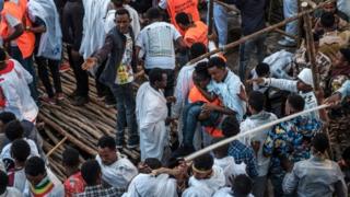 Injured are carried away from the collapsed stand