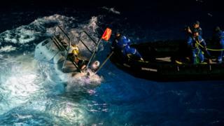 Embarcação de apoio a mergulho (DSV, na sigla em inglês) se prepara para expedição no mar, acompanhada por diversos membros da equipe