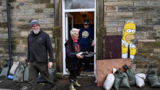 People begin the clean-up following yesterday's flooding in Newcastleton, Scotland.
