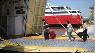туристы садятся на паром в порту Пирей
