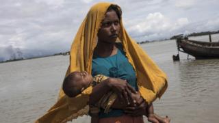 শিশু কোলে পালিয়ে আসা এক রোহিঙ্গা নারী