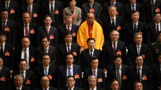 Делегаты стоят во время исполнения государственного гимна в конце пленарного заседания Всекитайского собрания народных представителей в марте 2019 года