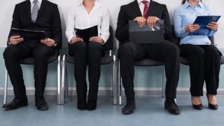 Cuatro personas esperando por una entrevista de trabajo