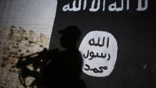 Irak'ta güvenlik görevlileri IŞİD bayrağı önünde