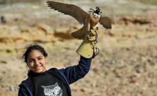 A girl holds a falcon near October city on the outskirt of Cairo, Egypt - Friday 7 February 2020