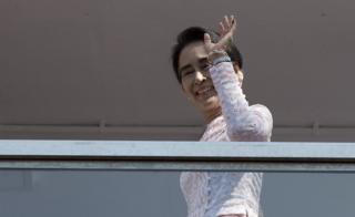 Myanmar opposition leader Aung San Suu Kyi waves to a small crowd and the media after delivering a speech from the balcony of the National League of Democracy (NLD) headquarters in Yangon on 9 November 2015.