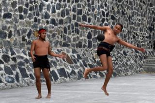 Men play a pre-Columbian ballgame called "Tlachtli" -in Nahuatl indigenous language- which rule is to hit a "Ulamaloni" (solid rubber ball) with the hip or shoulder, during a match at the FARO Poniente cultural centre in Mexico City on August 21, 2019.