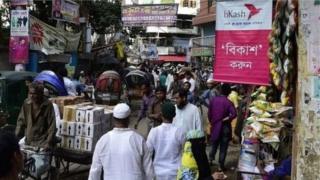 রাস্তার মোড়ে মোড়ে এরকম বহু জায়গায় চলছে টাকা-পয়সা পাঠানোর জমজমাট মোবাইল ব্যাংকিং