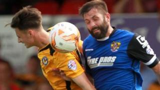 Aaron Collins of Newport County and Dean Wells of Stevenage challenge for the ball