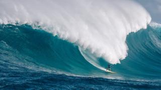 A surfer riding "jaws" in Maui, Hawaii