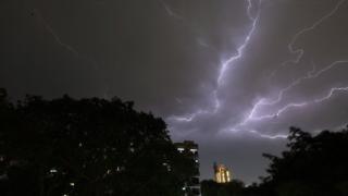 Lightning strikes over residential apartments during a thunderstorm on the outskirts of the Indian capital Delhi on 2 May 2018