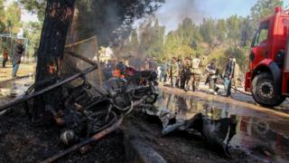 Afghan National Army (ANA) soldiers and firefighters extinguish a fire at the site of a suicide car bomb attack in Lashkar Gah in Helmand Province on February 11, 2017.