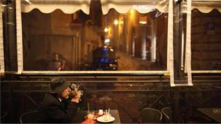 Homem em cafeteria, observando, sem fazer nada - il dolce far niente italiano